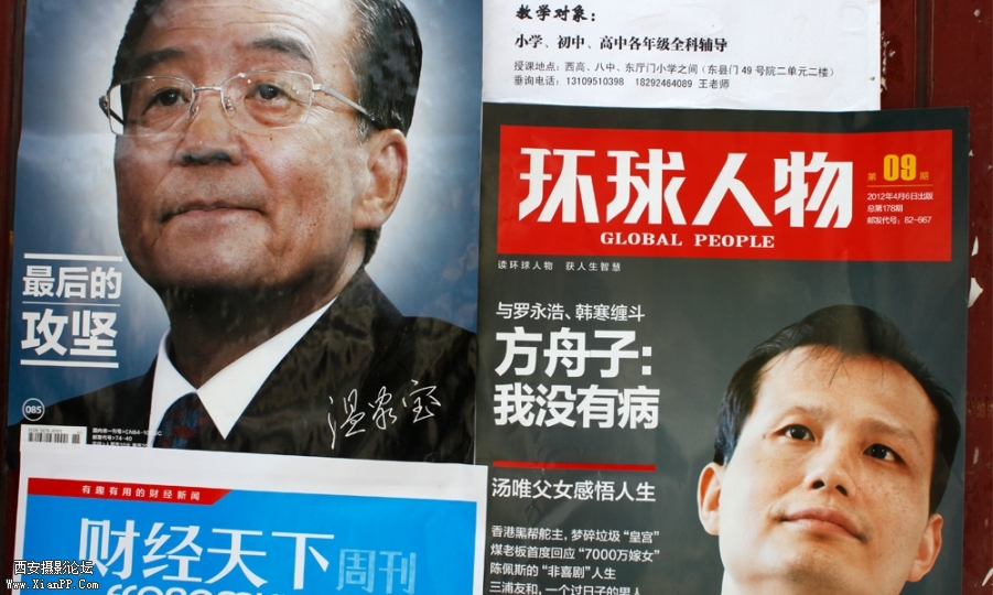 一个报亭侧面贴满了海报，温总理也在其中